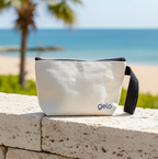 White pouch with 'gelo' branding on a stone ledge by the beach
